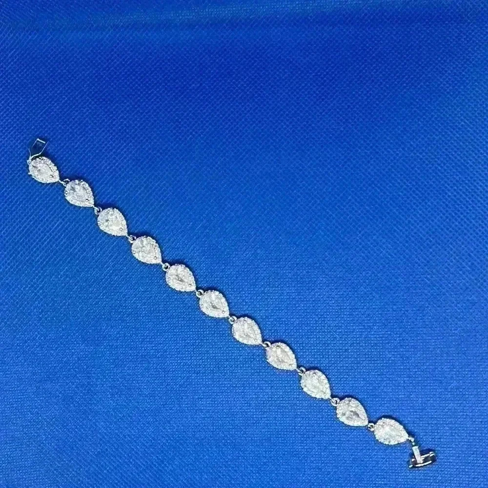Pear shape cubic zirconia bracelet with halo mounting.